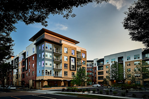 A modern apartment building with a mix of brick and panel facades.