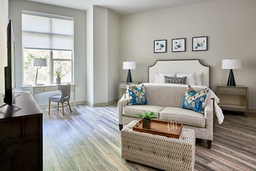 A living room with a couch, a chair, a coffee table, and a television.