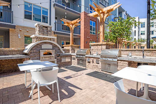 A patio with a table, chairs and a fireplace.