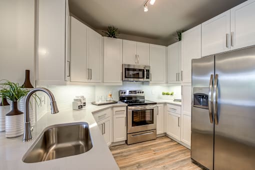 A modern kitchen with stainless steel appliances and white cabinets.
