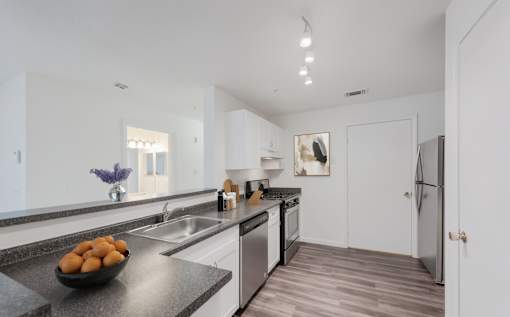 A kitchen with a bowl of fruit on the counter at Residences at Westborough Station, Westborough, MA