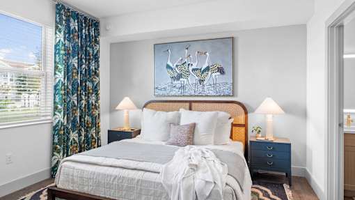 A bedroom with a large bed and a painting of two birds on the wall. at Lucie at Tradition Apartments, Florida, 34987
