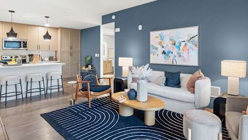 A modern living room with a kitchen area in the background. at Lucie at Tradition Apartments, Florida