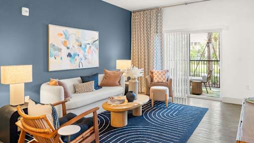 A living room with a blue wall and a painting on it. at Lucie at Tradition Apartments, Port St. Lucie, FL, 34987
