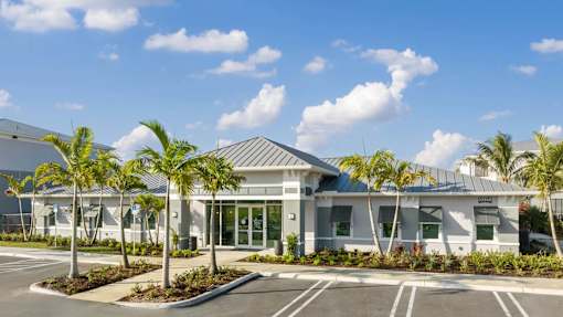 A building with a parking lot in front of it. at Lucie at Tradition Apartments, Port St. Lucie 34987