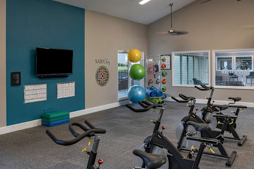A gym with exercise equipment and a TV.