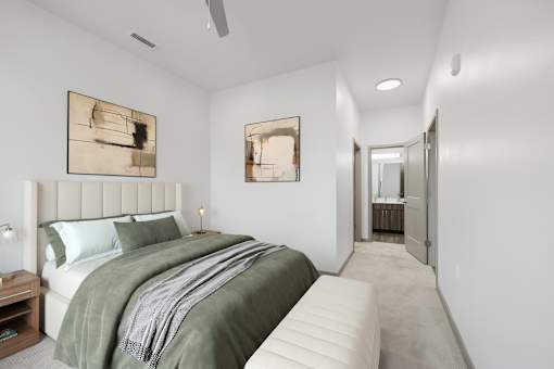 A bedroom with a large bed and two artworks on the wall.
