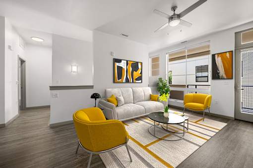A modern living room with a grey sofa, yellow chairs and a painting on the wall.