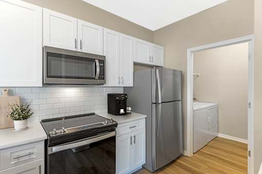 Kitchen and attached laundry room with stainless steel appliances and modern finishes