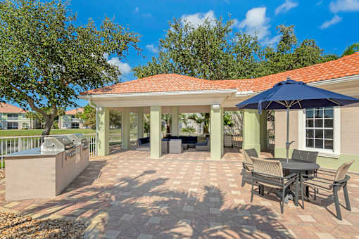 Outdoor community grilling area with dining tables and lounge seating