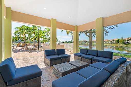 A patio with blue cushioned furniture and a view of the water