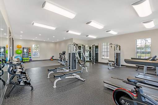 A spacious gym with a variety of equipment including treadmills, weights, and exercise machines.