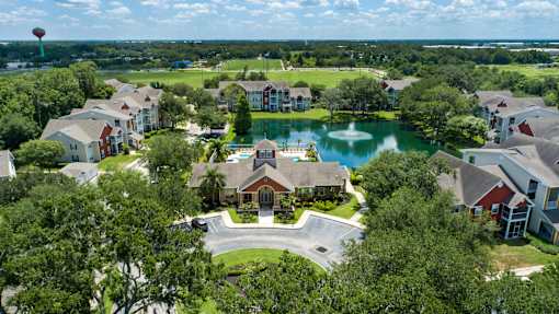 A bird's eye view of a residential area with a lake and a hot air balloon in the distance.