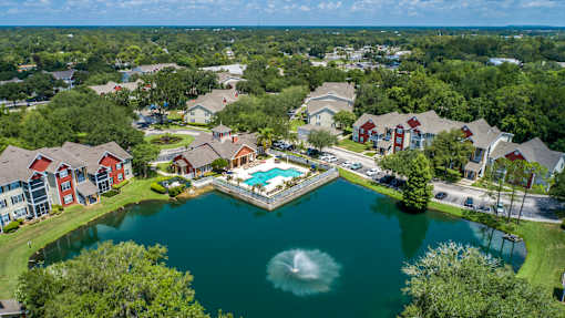 A bird's eye view of a residential area with houses surrounding a lake.