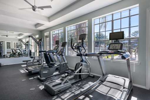 A gym with treadmills and elliptical machines.