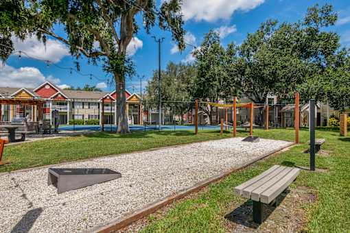 A playground with a slide, swings, and a bench.