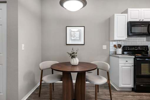 A kitchen with a table and chairs.