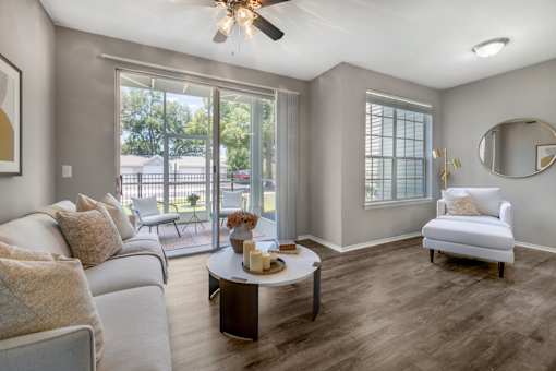 A living room with a white couch, a coffee table, and a ceiling fan.