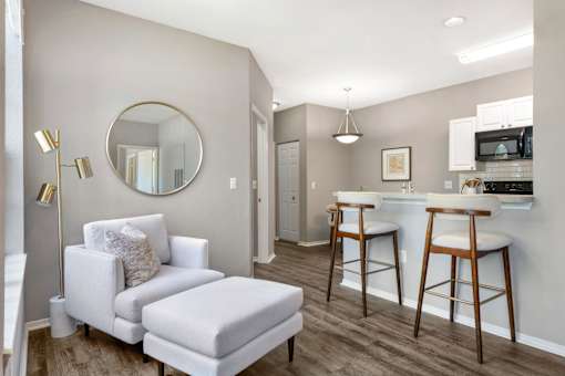 A modern living room with a white chair and ottoman.