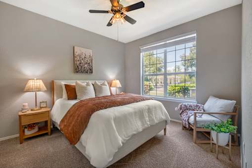 A bedroom with a large bed and a ceiling fan.