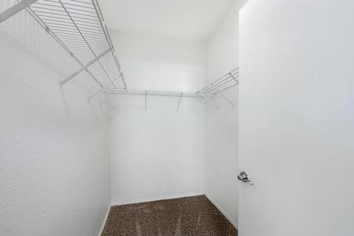 A white room with a brown carpet and a door on the right.