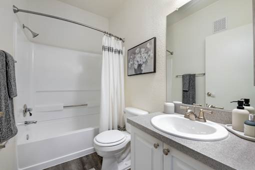 A white bathroom with a toilet, sink, and bathtub.