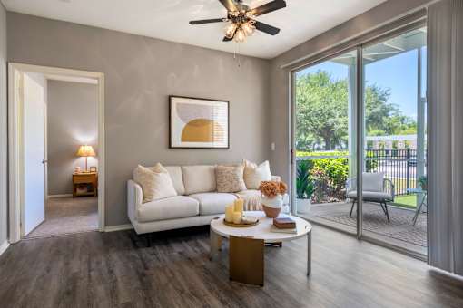 A living room with a white couch and a ceiling fan.