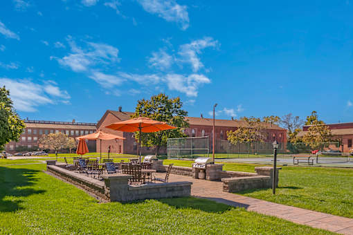 Outdoor lounge area with two grills and umbrellas