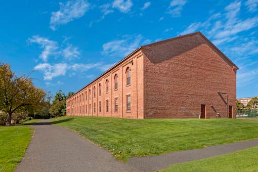 A long brick building with a pathway in front of it.