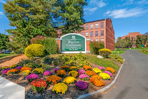 An entrance sign that says Biglow Commons  leading into the front of the apartment community