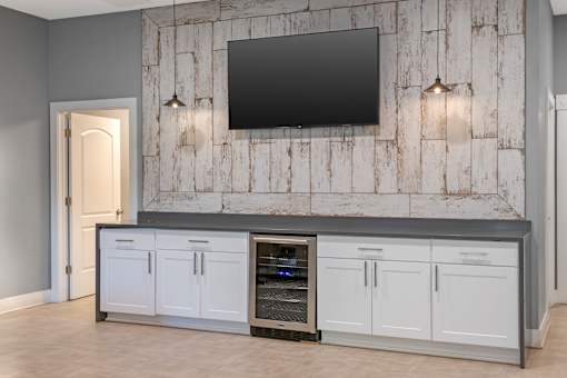 A modern kitchen with a large island and a flat screen TV mounted on the wall.