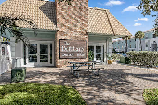 The Brittany Apartment Homes building has a brick facade and a covered patio area.