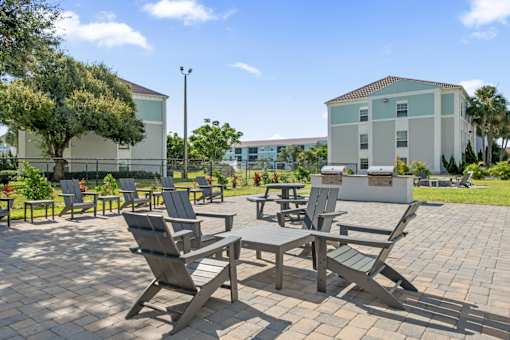 A patio with chairs and a table in front of a building.
