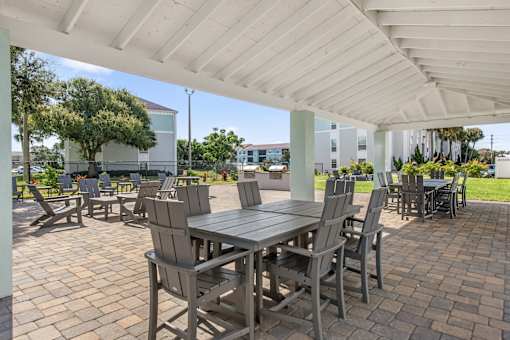 A patio with a table and chairs under a white roof.