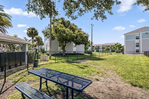 A park with a blue picnic table and bench.