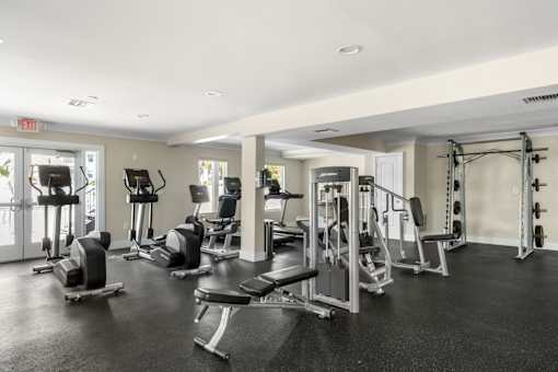 A gym with a variety of equipment including weights and cardio machines.