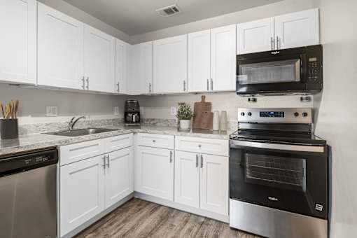 A kitchen with white cabinets and stainless steel appliances.