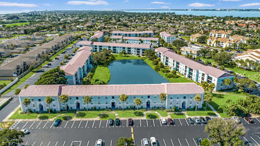 A large white building with a pool in front of it.