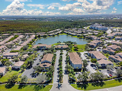A bird's eye view of a residential area with a lake in the middle.
