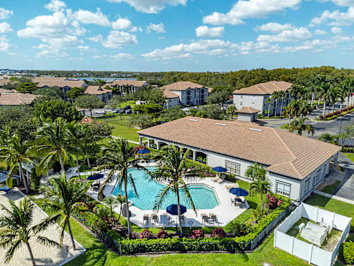 A large white building with a pool in front of it.
