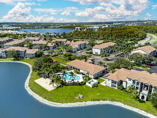 A bird's eye view of a residential area with a swimming pool and a lake.