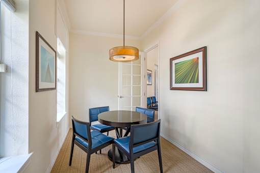 A dining room with a round table and chairs.
