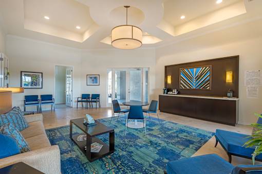 A living room with a blue rug and a white sofa.