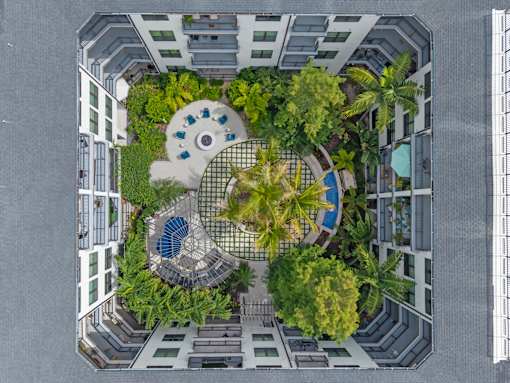 A top-down view of a courtyard surrounded by buildings with a fountain in the center.
