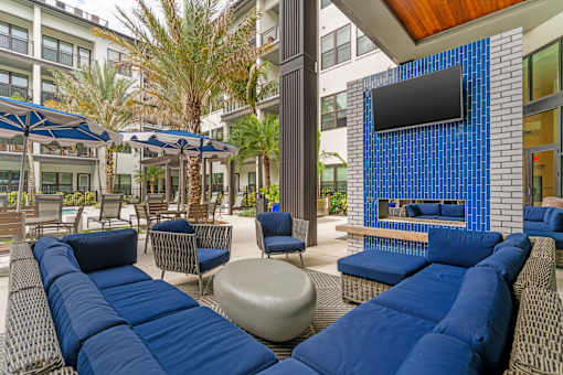 A blue couch is in the middle of a patio.
