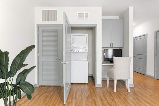 A white chair is in front of a small kitchen.