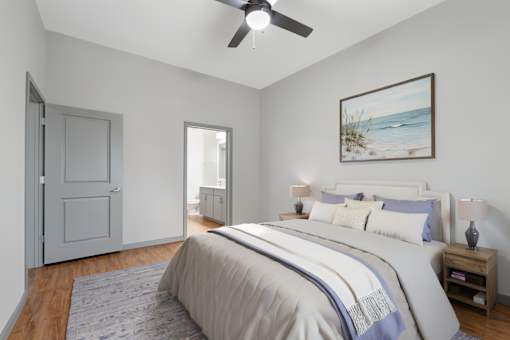 A bedroom with a large bed and a ceiling fan.