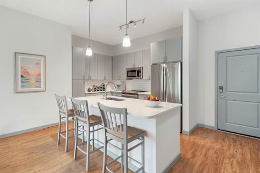 A kitchen with a white countertop and stainless steel appliances.