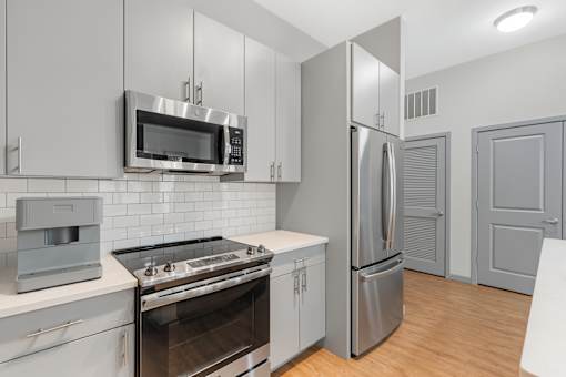 A modern kitchen with stainless steel appliances and white cabinets.