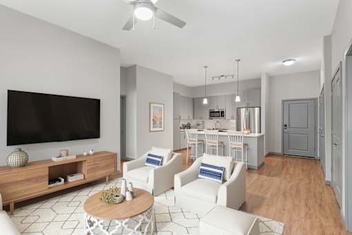 A living room with a television, white chairs, and a wooden coffee table.